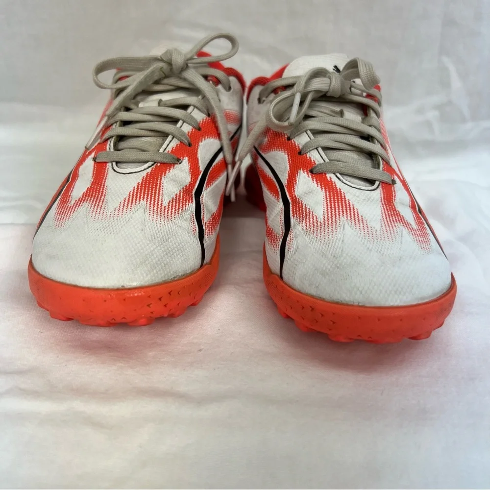 Puma kids turf shoes in white, bright coral and black.